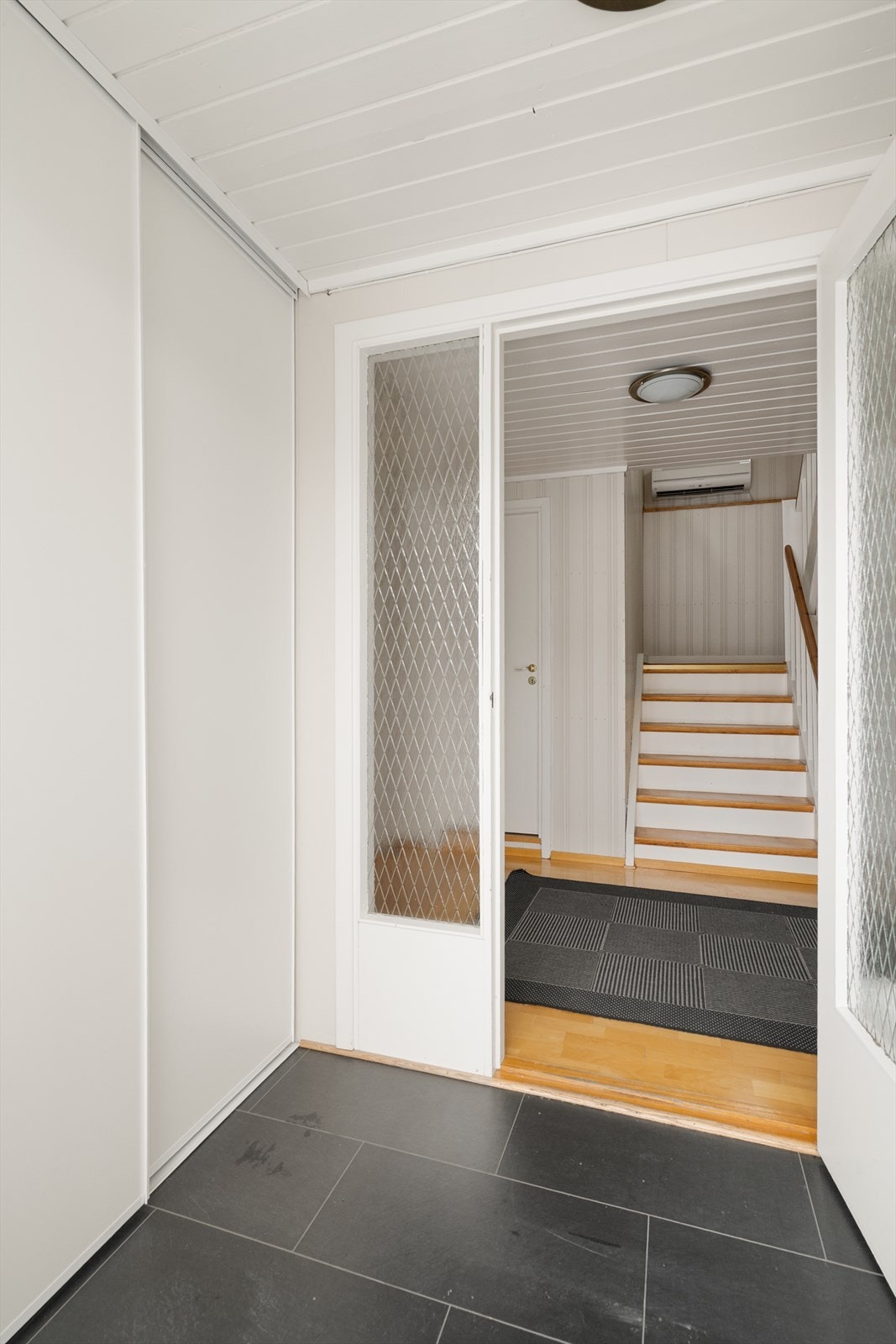 Boligen har romslige gangarealer, med vindfang og hall med trapp opp til hovedetasjen. I vindfanget er det etablert skyvedørsgarderobe med plass til sko- og ytterklær. Galleribilde
