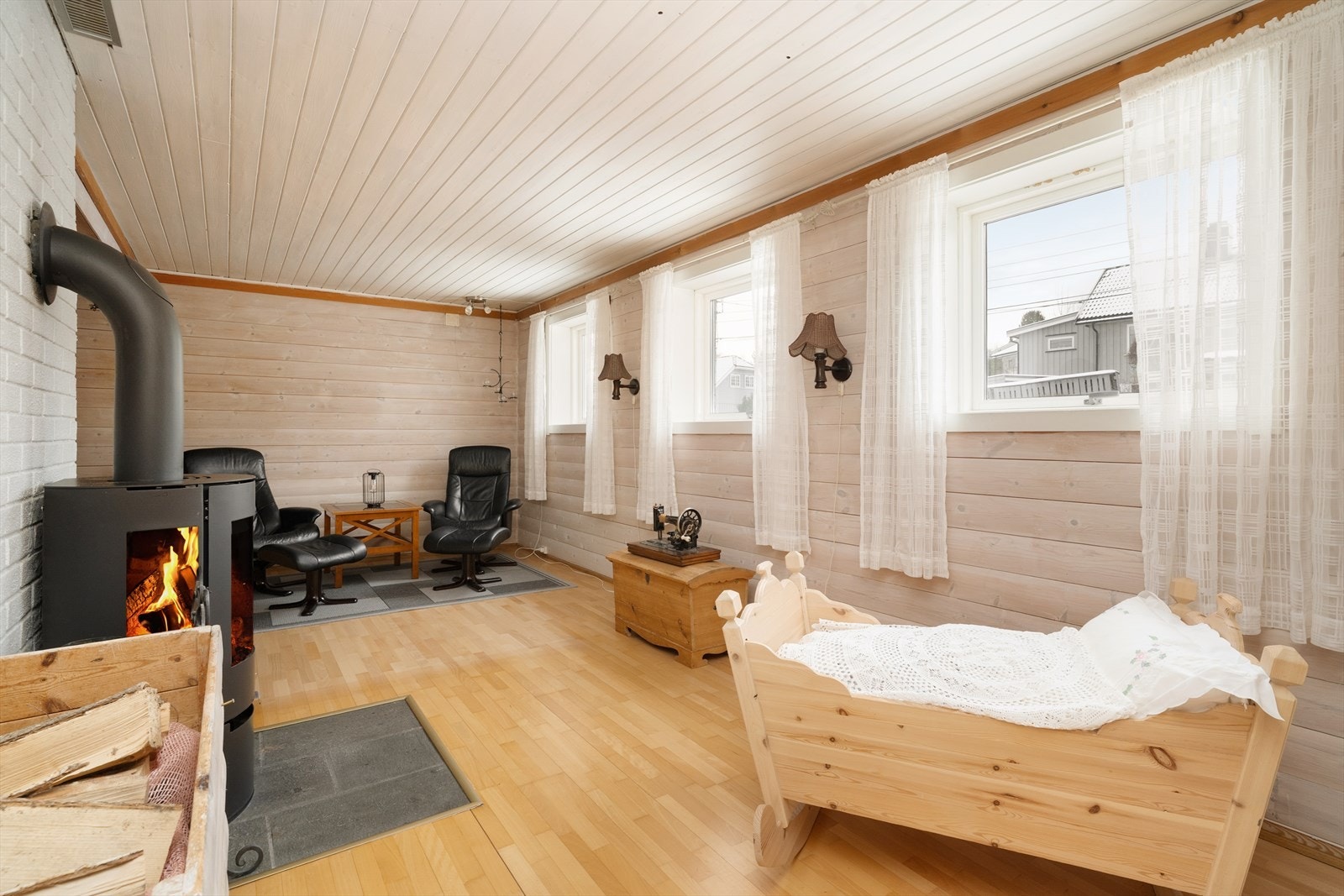 Boligen har en stor og koselig kjellerstue med parkettgulv og liggende panel på veggene. Galleribilde