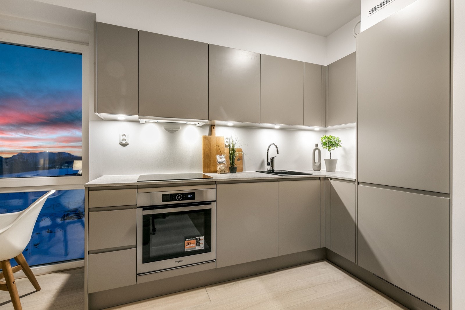 Kjøkkenet har en praktisk hjørneløsning, som gir rikelig av skap og benkeplass. Galleribilde