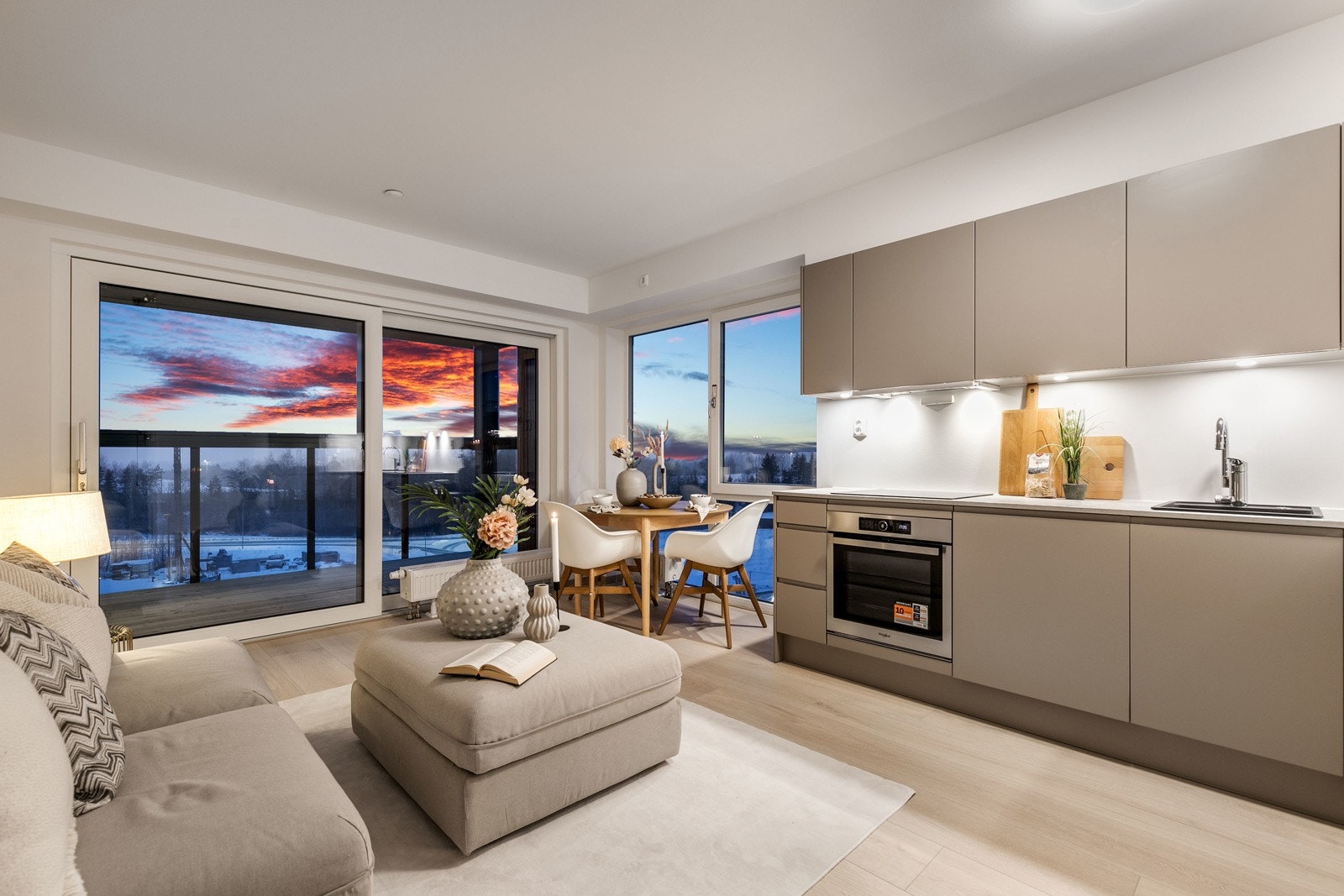 Lekkert kjøkken i åpen løsning mot stue, med integrerte hvitevarer. Galleribilde