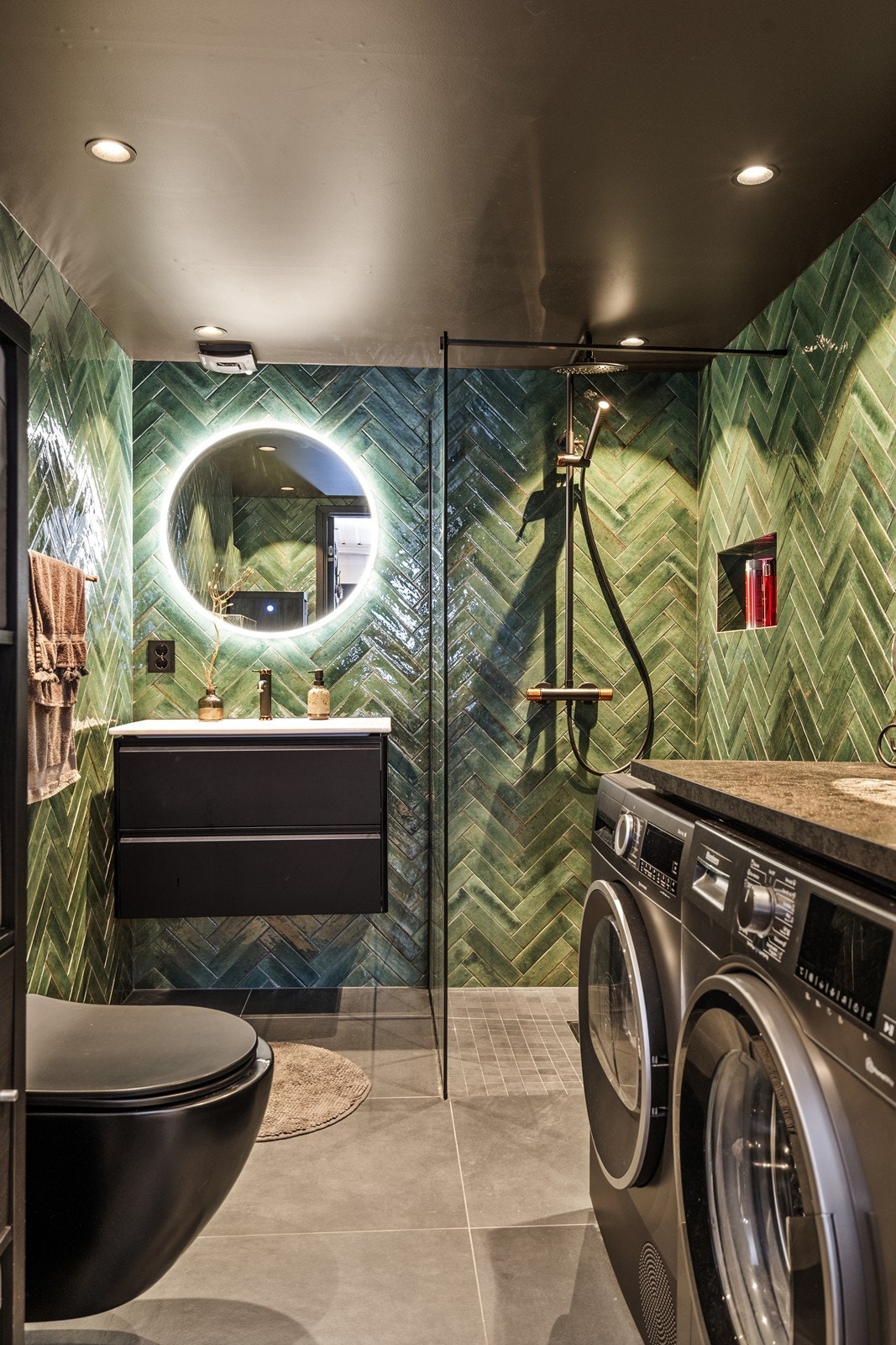 Badet er helfliset og har en moderne utførelse med vegghengt toalett og dusjhjørne. Galleribilde