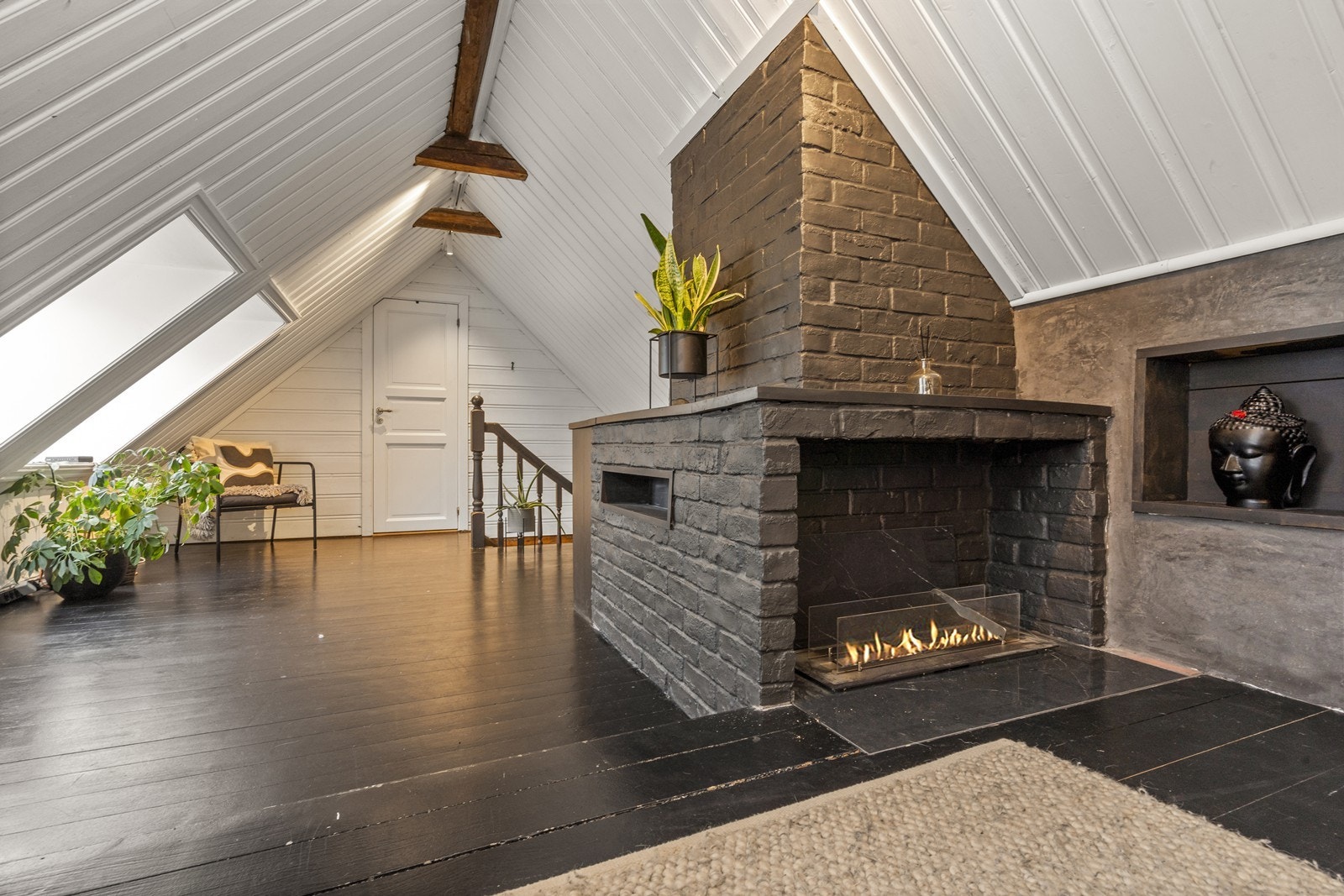 En dekorativ, moderne peis er et sentralt element i rommet. Galleribilde