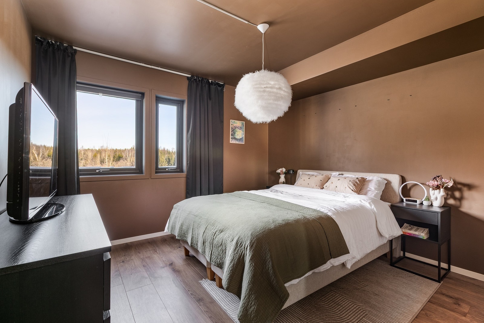 En velpassende mørk og varm bruntone på både gulv og vegger skaper en lun, avslappende atmosfære i hovedsoverommet. Galleribilde