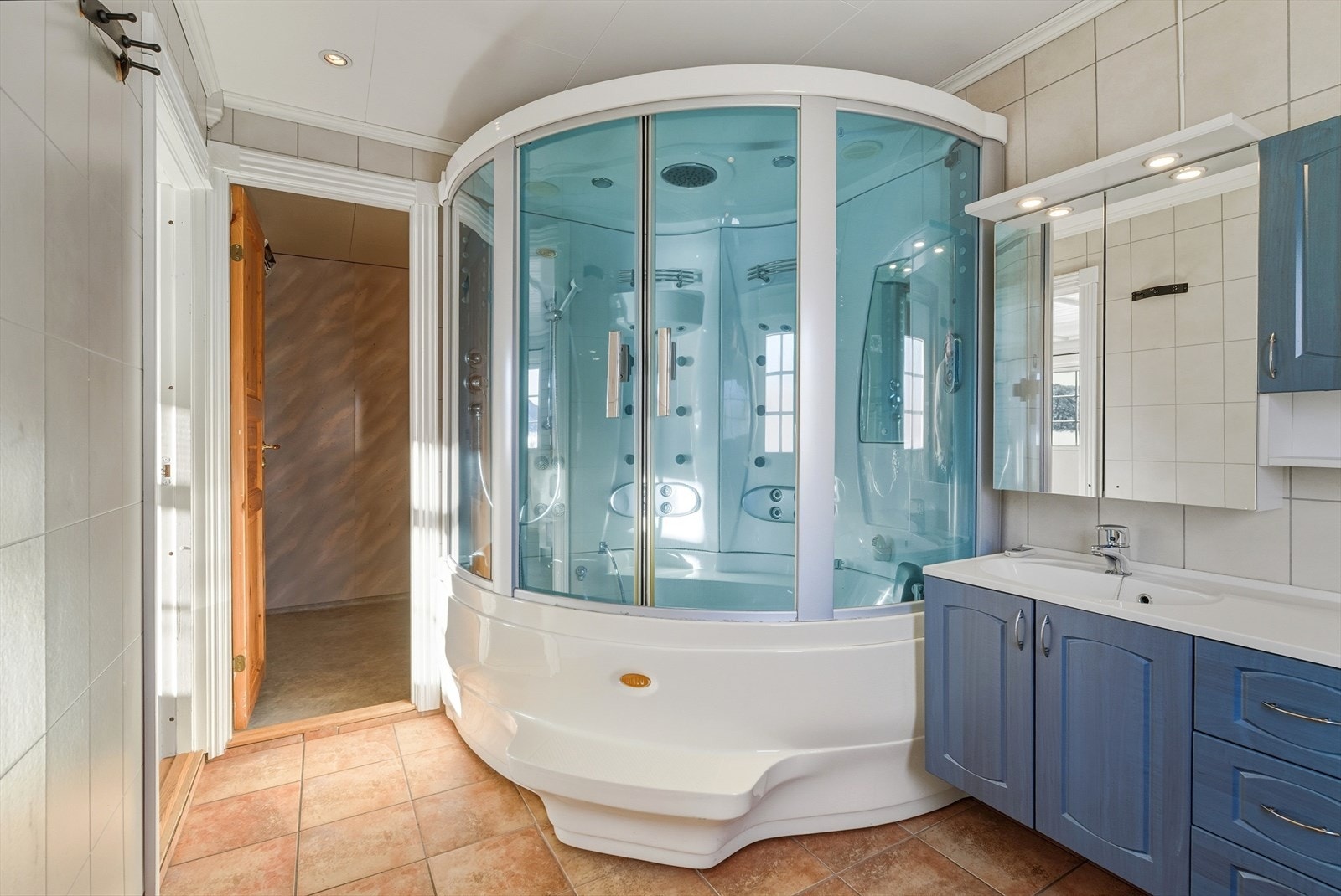 Dusjkabinett med boblekar, wc på vegg og servant nedfelt i servantskap Galleribilde