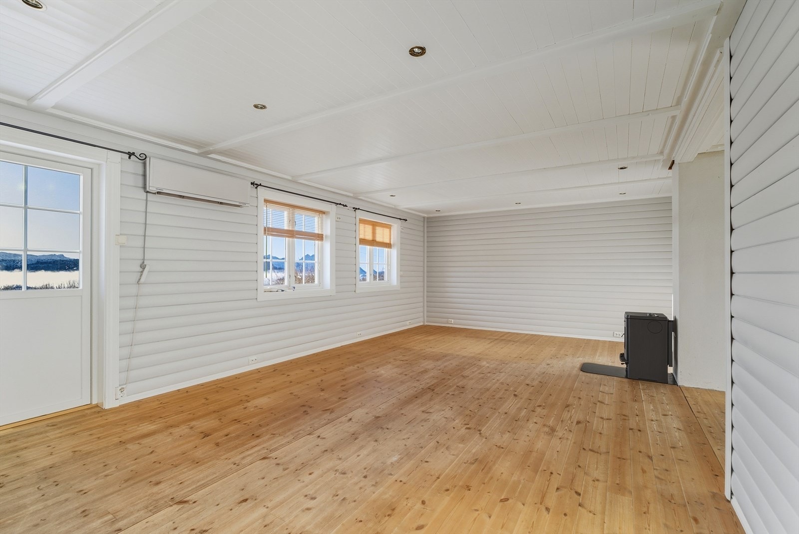 Åpen og romslig stue med flere vinduer og godt lysinnslipp Galleribilde