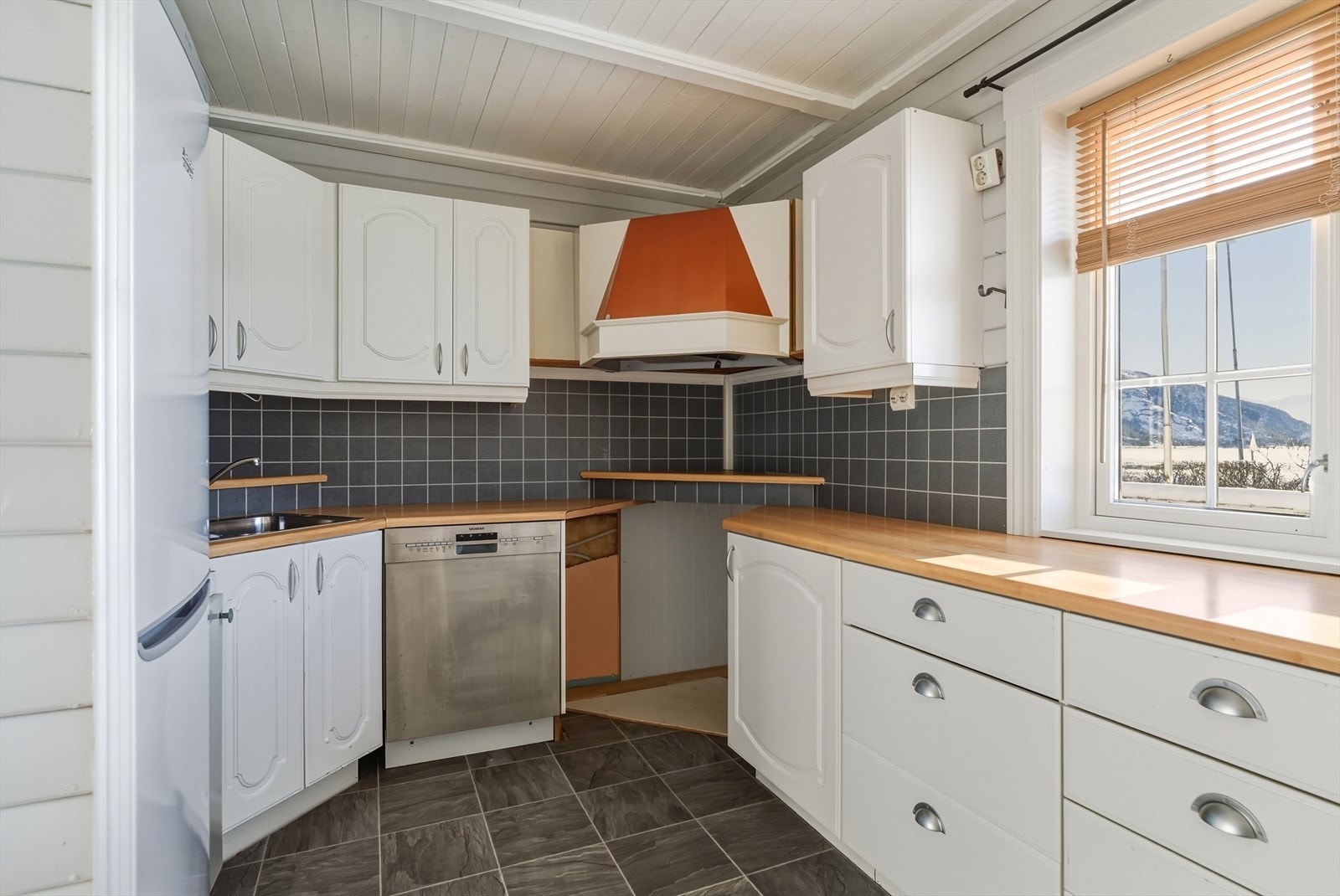 Kjøkken med lyse fronter, god benkeplass og vindu over arbeidsområdet Galleribilde