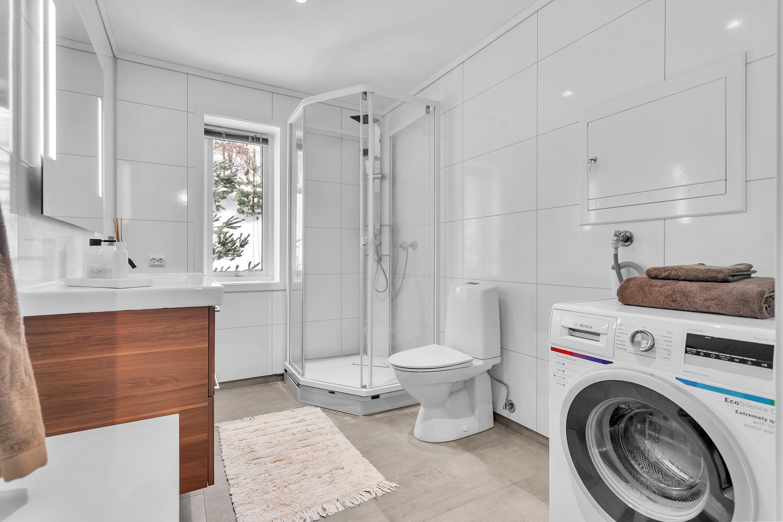 Rommet har innredning med nedfelt servant, toalett, dusjkabinett og opplegg for vaskemaskin. Galleribilde
