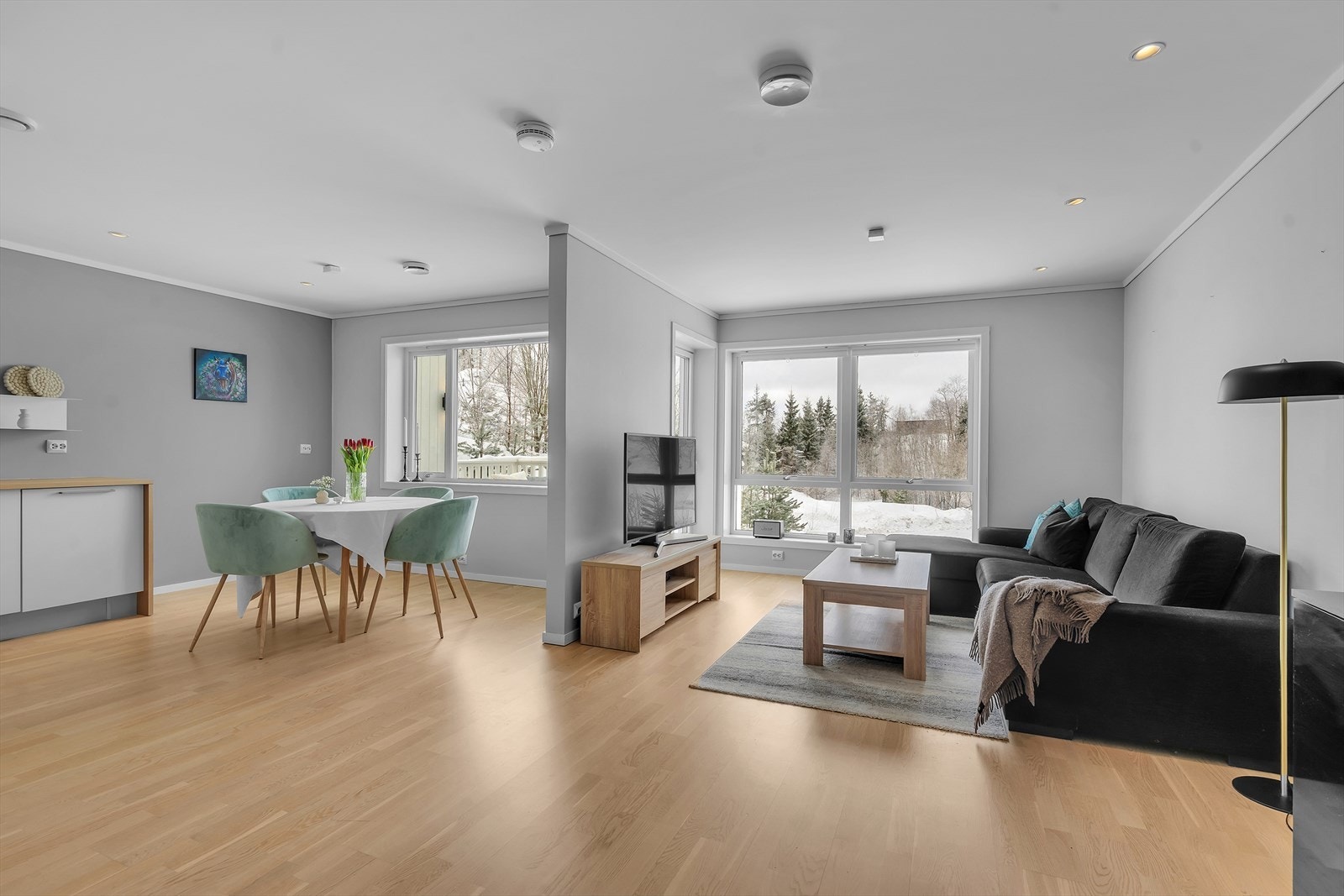 Åpen stue-/kjøkkenløsning i lyse fargevalg og parkettgulv. Galleribilde