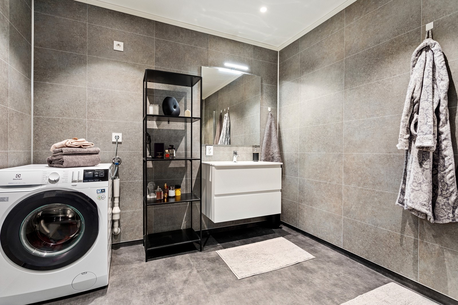 Flott bad med belegg på golv og baderomsplater på veggar. Opplegg til vaskemaskin. Galleribilde