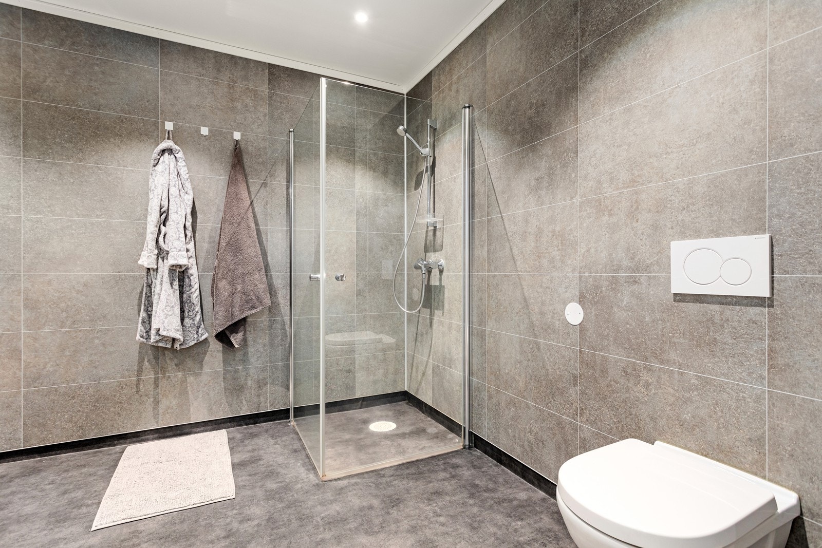 Elles er badet utstyrt med dusjhjørne og vegghengt toalett. Galleribilde