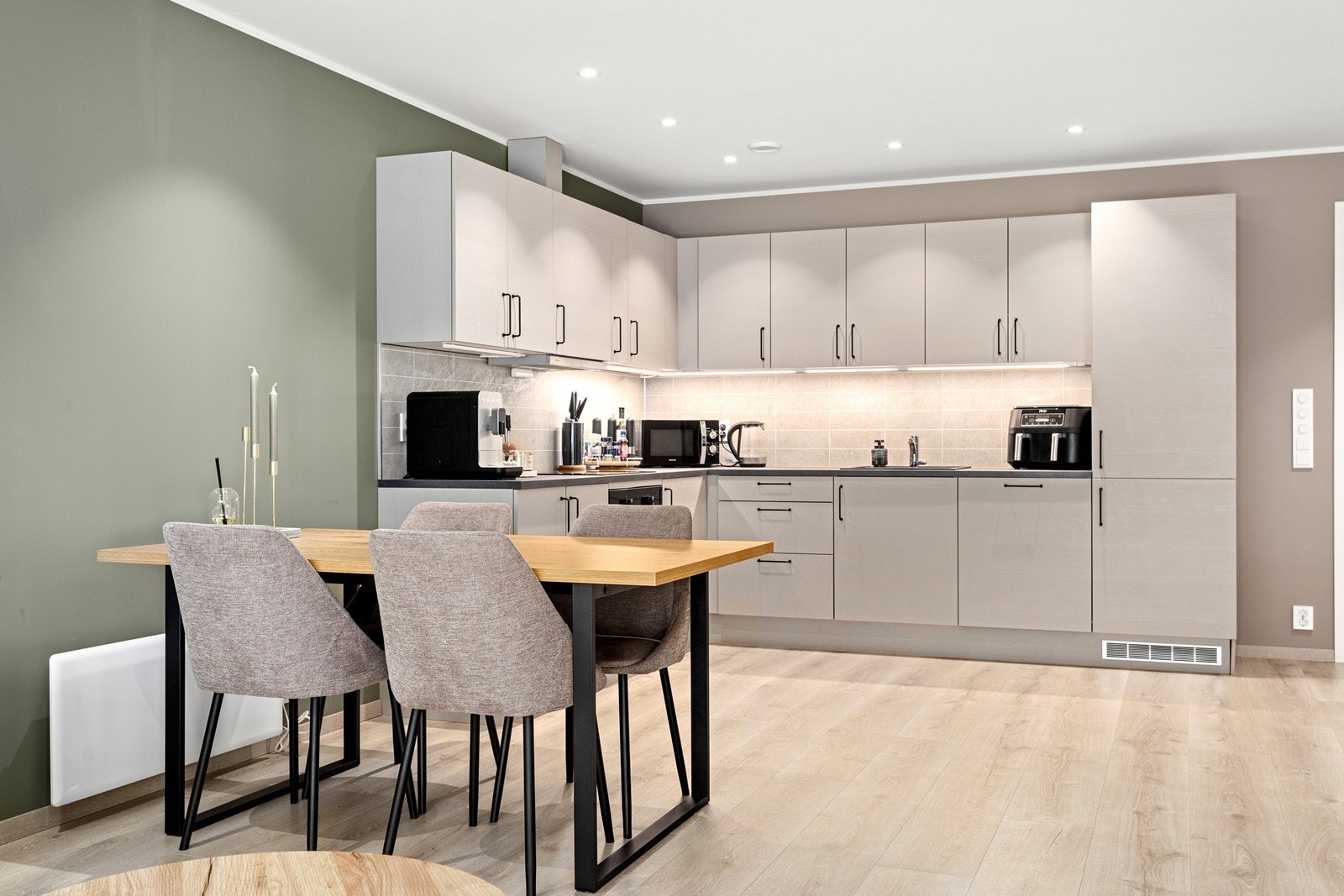 Stilrein og moderne kjøkkeninnreiing med lys grå, slette frontar. Galleribilde