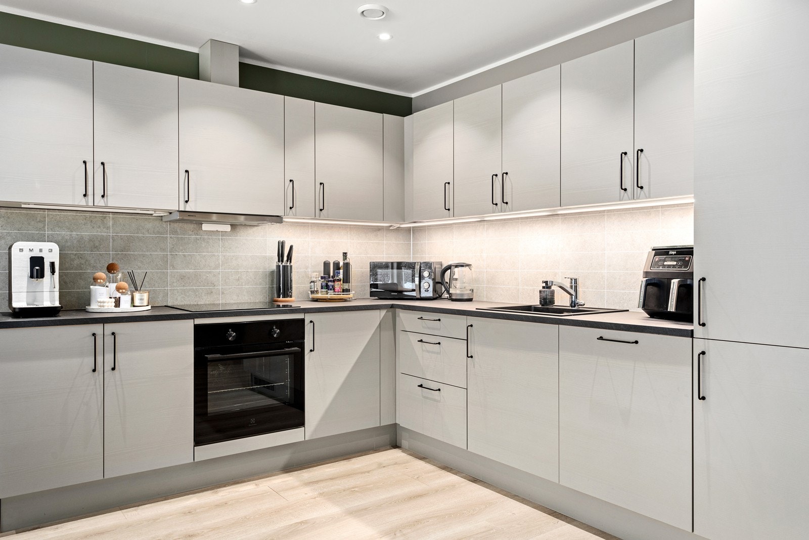 Integrerte kvitevarer i form av platetopp, steikeomn, oppvaskmaskin og kjøl/fryseskap. Galleribilde