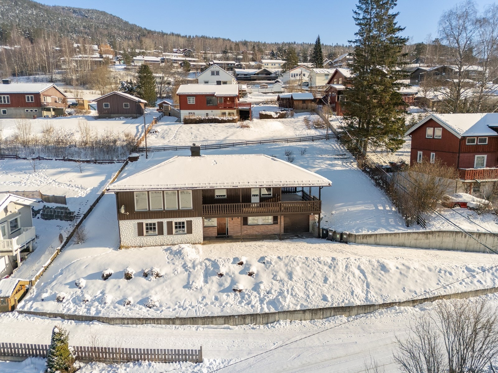 Tomten er skrånende med noen flate partier, og er opparbeidet med støttemurer, plen og prydbusker. Galleribilde
