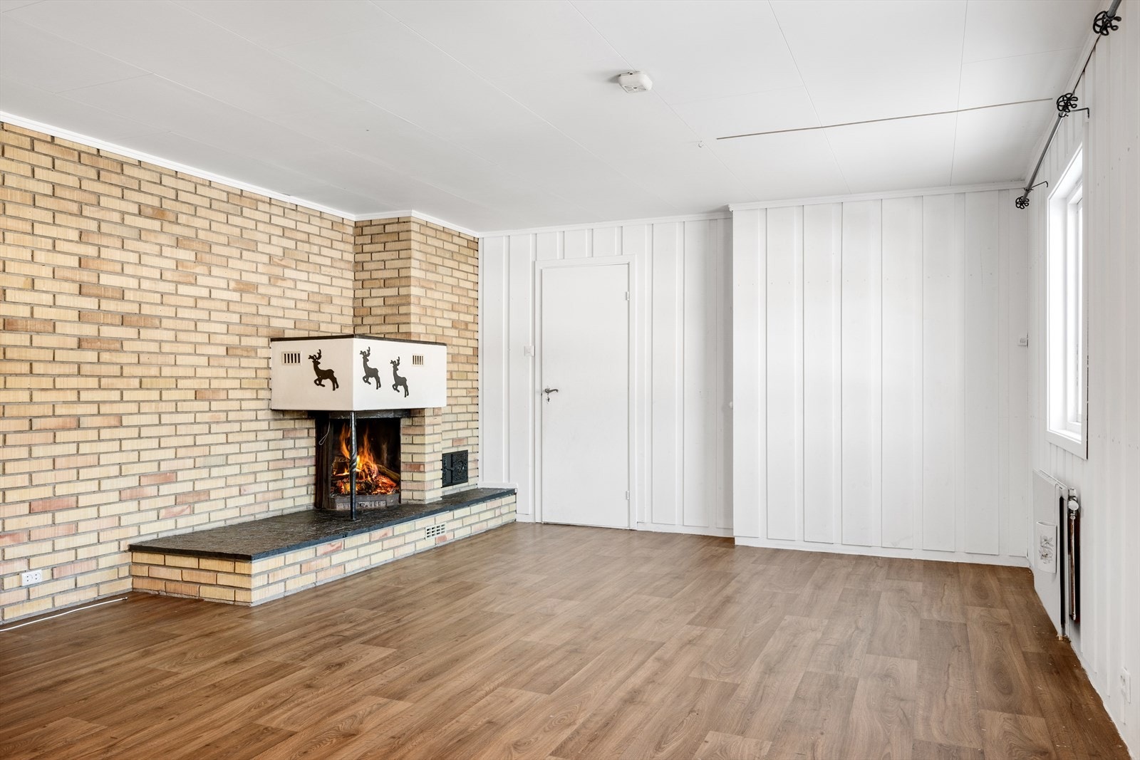 Boligen har en romslig kjellerstue med en hyggelig peis. Galleribilde