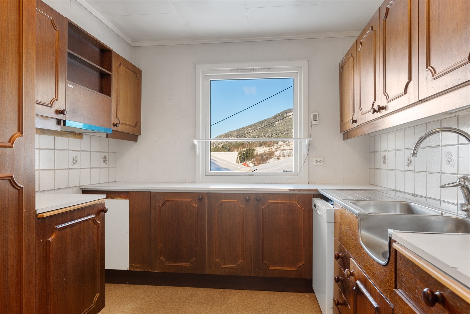 Kjøkkenet har eldre innredning med profilerte fronter og laminert benkeplate. Galleribilde