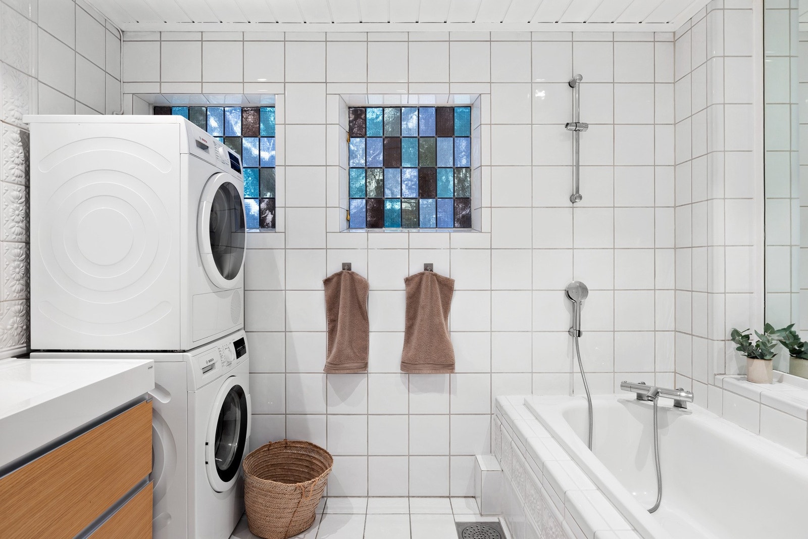 Delikat baderom med badekar og dusjarmatur. Opplegg for vaskemaskin. Galleribilde