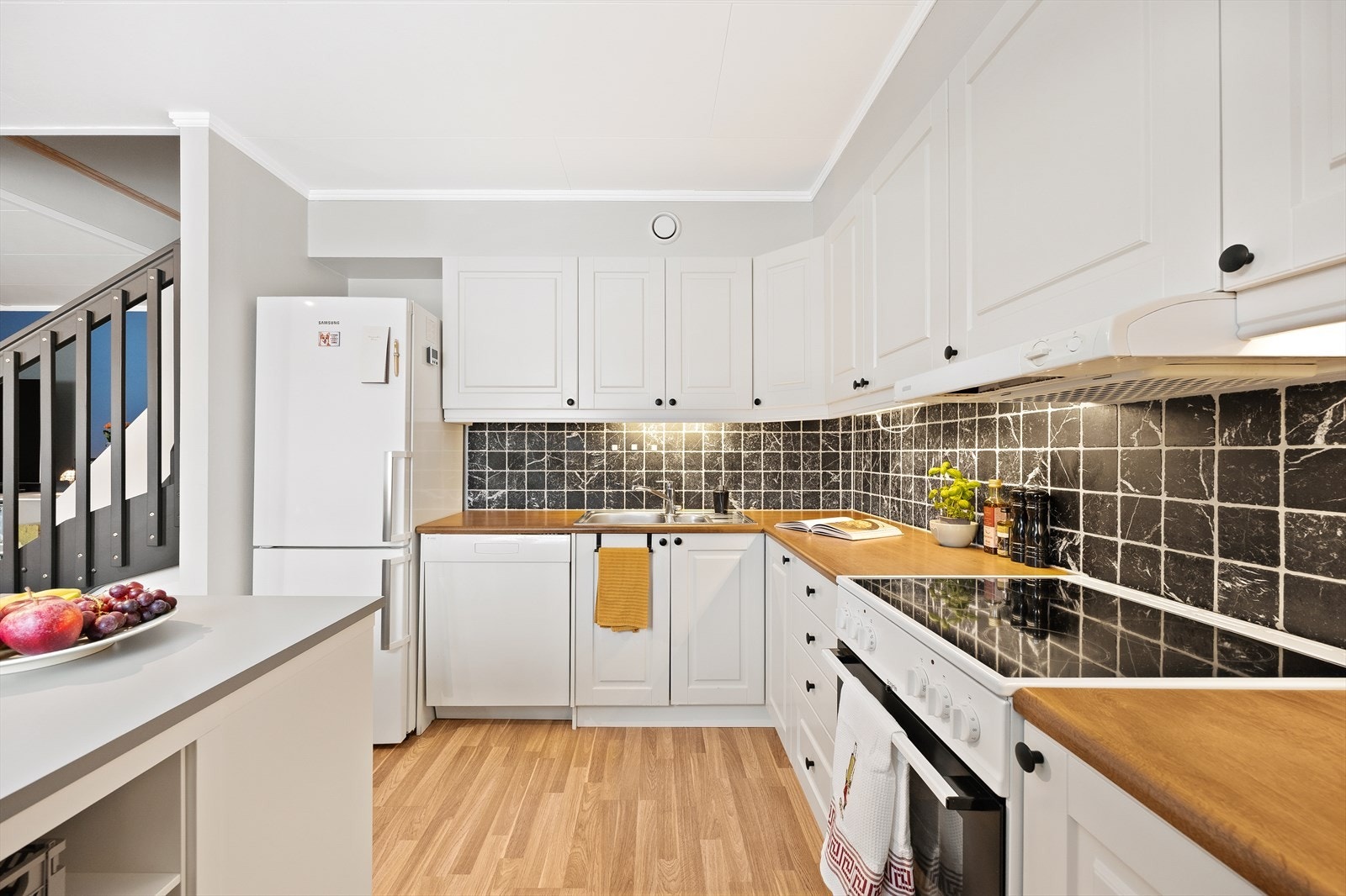 Innredningen er utstyrt med frittstående hvitevarer og en praktisk kjøkkenøy. Galleribilde