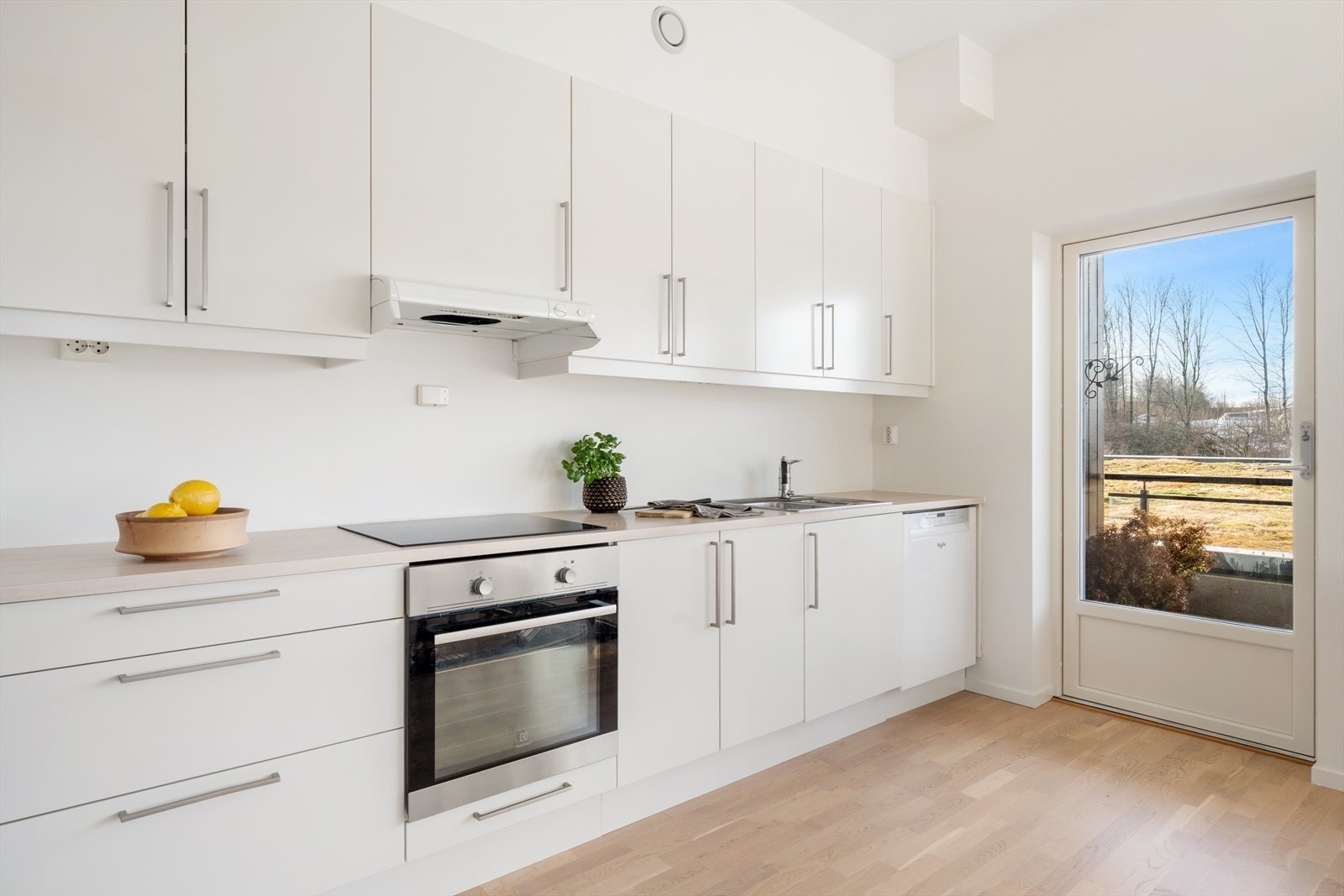 Kjøkkeninnredning med lyse glatte fronter og laminert benkeplate. Galleribilde