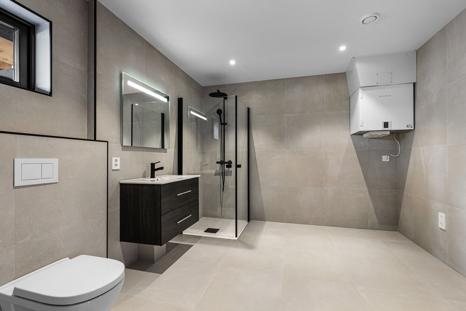 Dusjsonene er utført med mosaikkfliser 5x5 cm i samme serie, og begge bad har termostatstyrte varmekabler i gulvet. Galleribilde