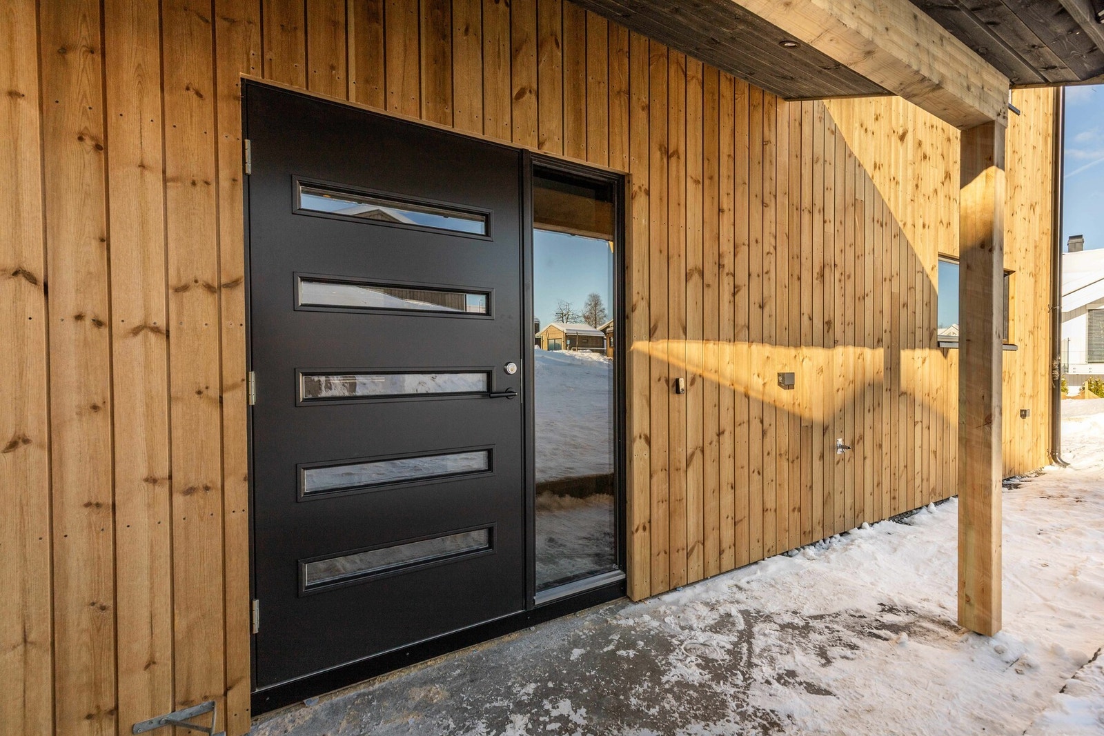 Boligen har et overbygd inngangsparti med downlights og støpt plate, klargjort for flislegging eller annen ønsket overflate Galleribilde