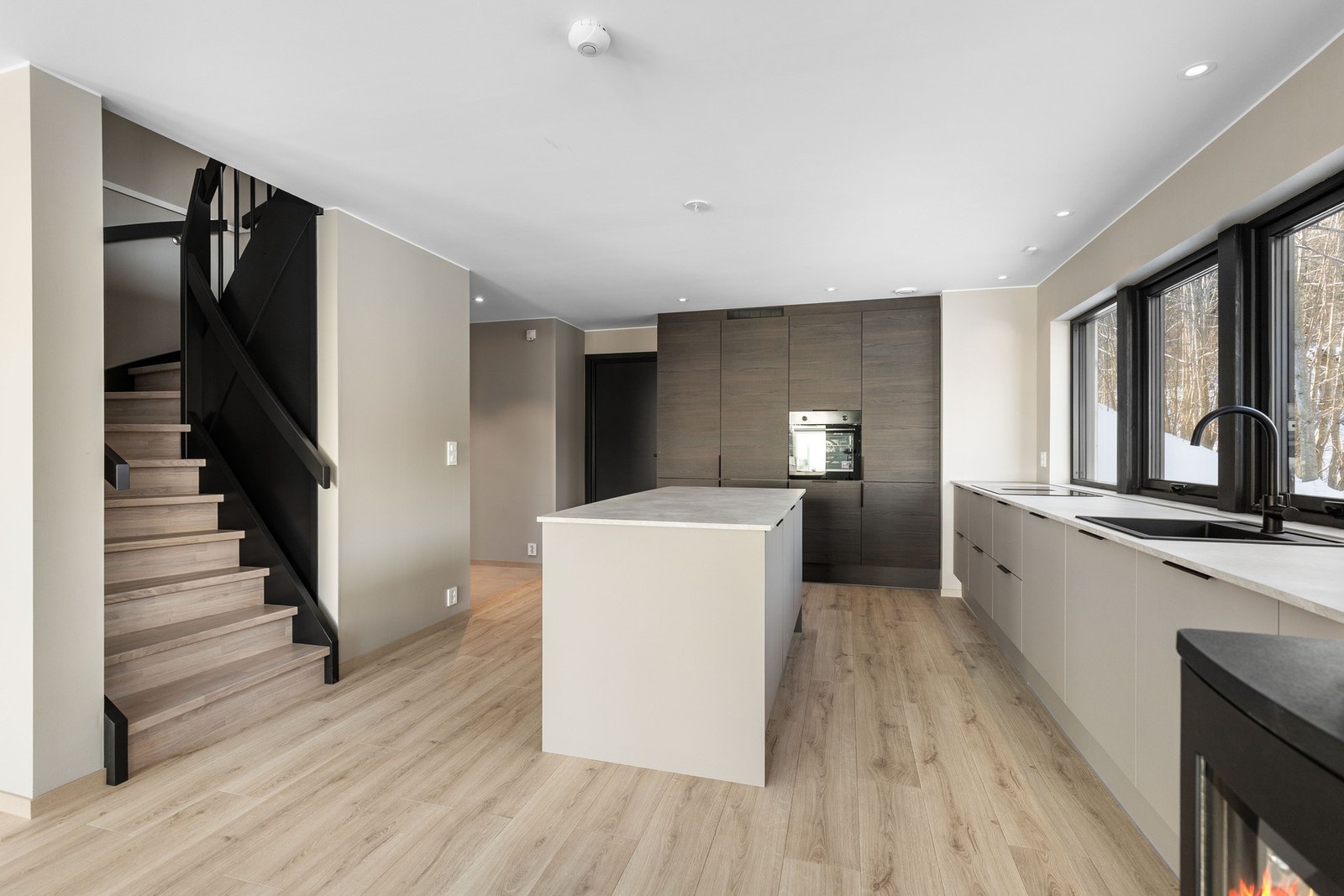 Videre er det en delikat trapp med lukkende trinn og sort rekkverk som fører deg opp til boligen andre etasje. Galleribilde