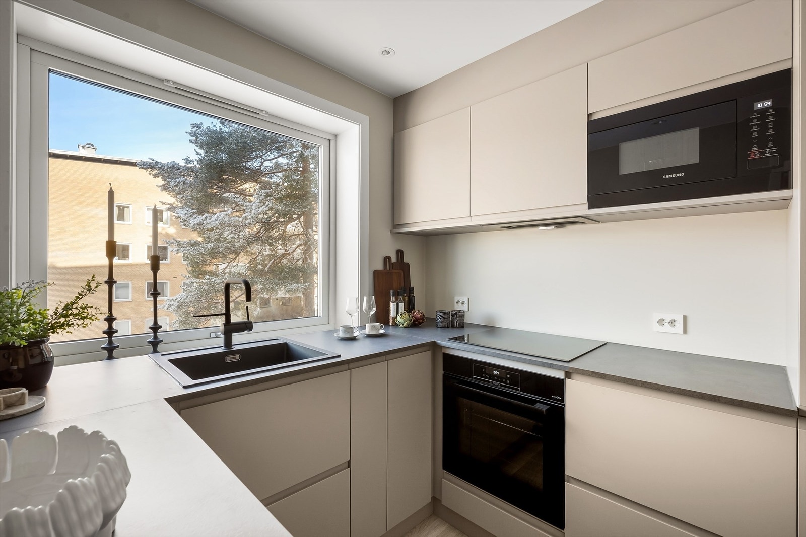 Kjøkkenet er utstyrt med integrerte hvitevarer fra kjente merket, inkludert induksjonstopp og mikroovn. Galleribilde