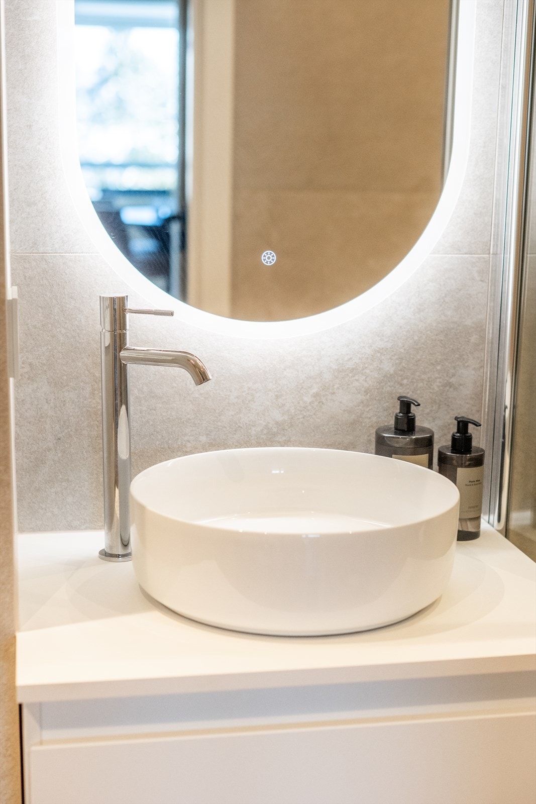 Servantskap med ovenpåliggende servant og speil med integrert belysning og forskjellige fargetoner. Galleribilde