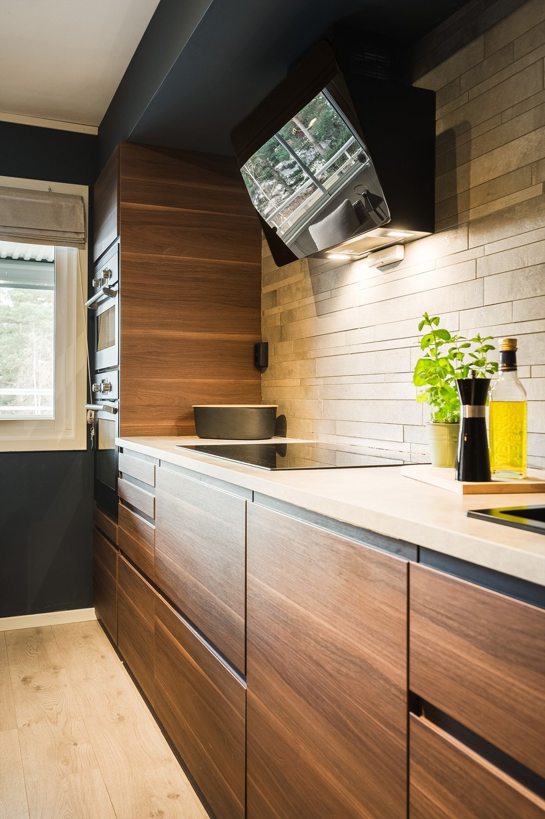 Innredningen har glatte fronter, laminert benkeplate med nedfelt oppvaskkum og fliser i benkeryggen. Det er montert komfyrvakt over platetoppen. Galleribilde