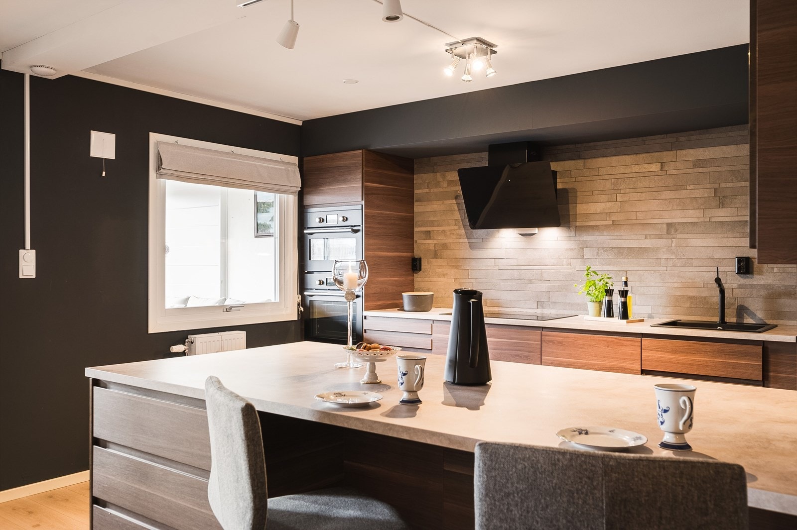 En stor kjøkkenøy deler naturlig av mot stuen, samtidig som den gir ekstra god skap- og benkeplass og en koselig sitteplass med barstoler. Galleribilde