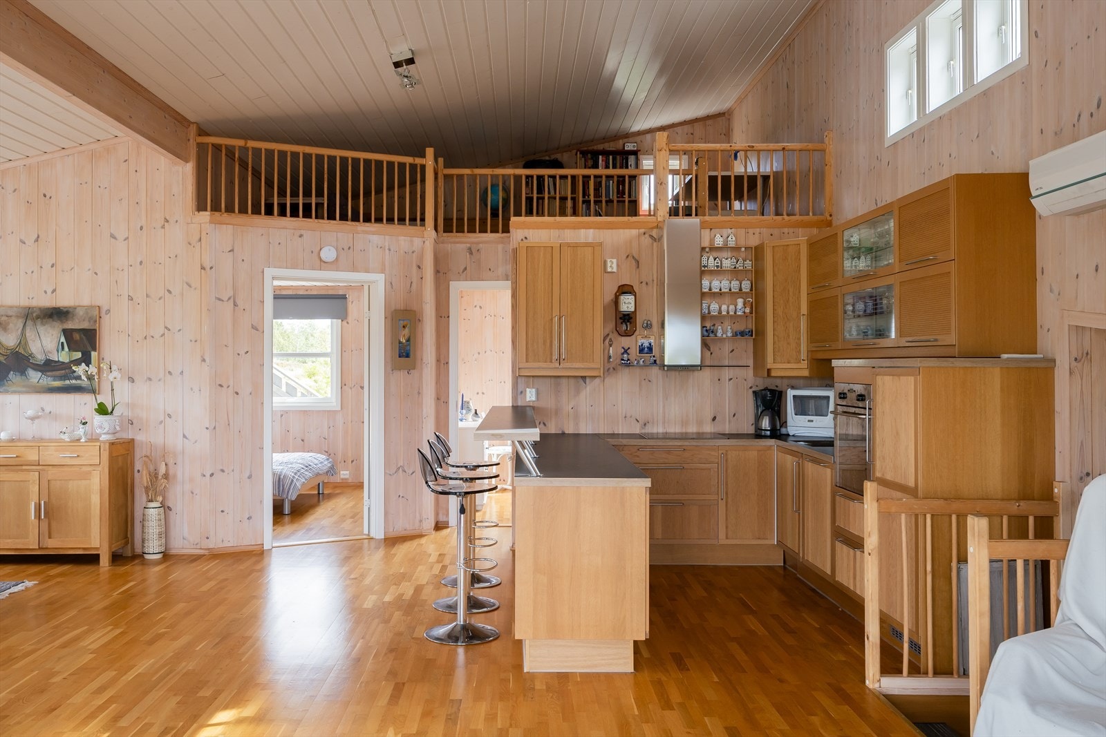 Kjøkken i harmonisk stil med stuen, utformet i praktisk U-form med barløsning. Galleribilde