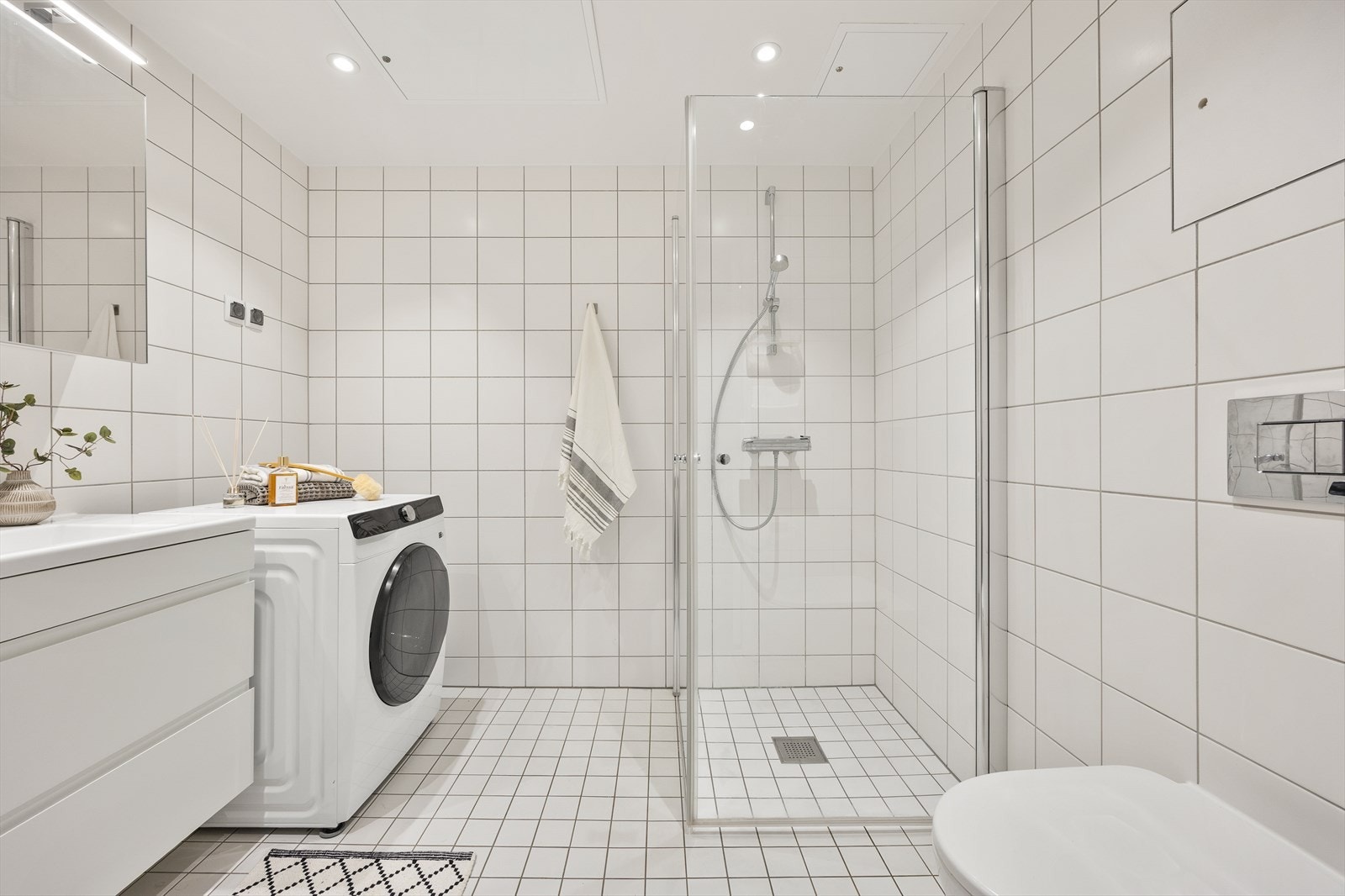 Her er det et praktisk dusjhjørne med innfellbare glassdører og et vegghengt toalett. Galleribilde