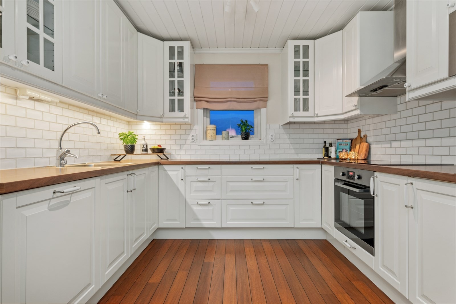 Kjøkkenet fra 2011 er oppført i en smart u-form med god skap- og benkeplass; her kan hele familien bli med å lage mat. Galleribilde