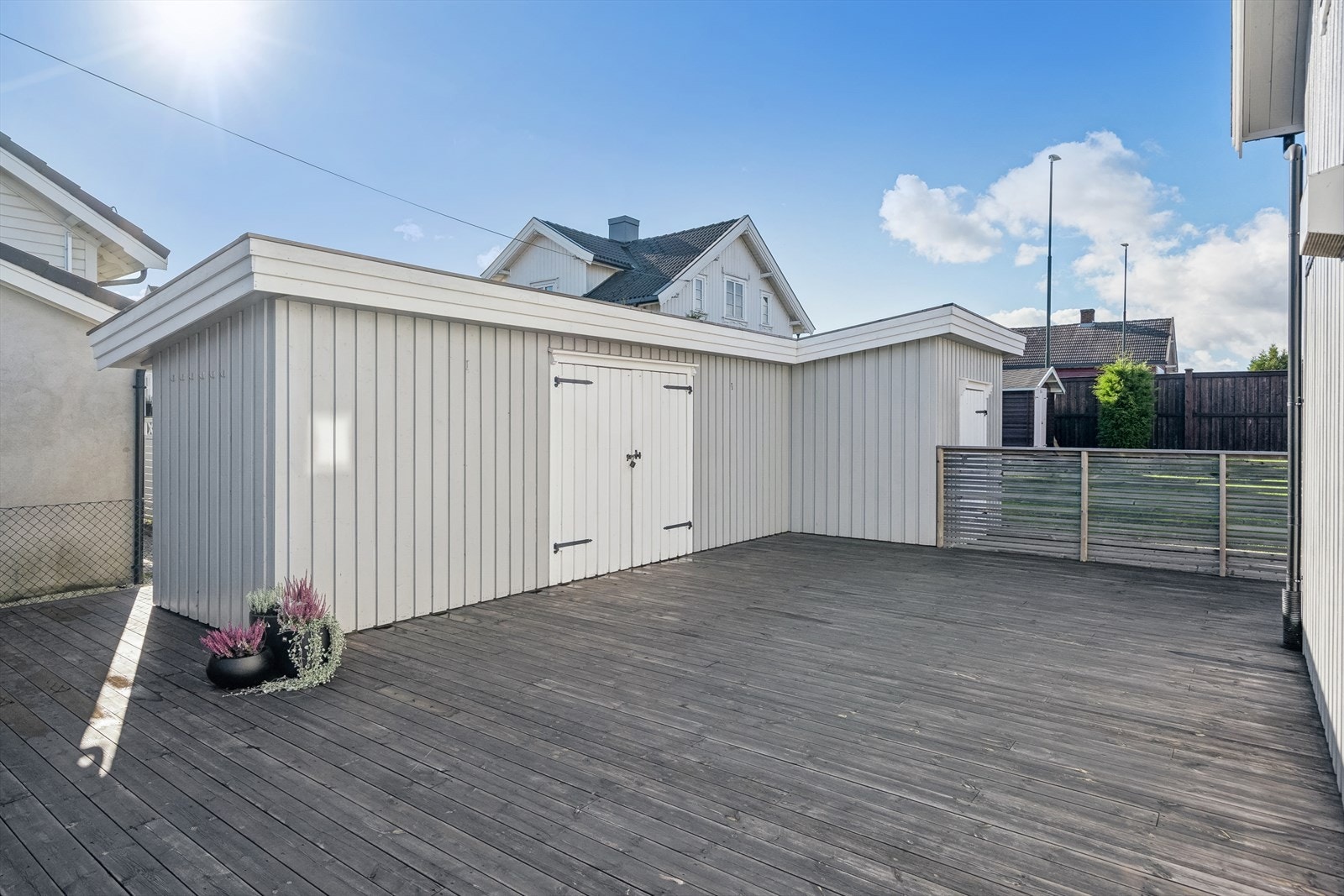 En sjelden stor terrasse som virkelig fungerer som en forlengelse av boligens oppholdsrom - både praktisk og stemningsfull med frittstående bod for ekstra oppbevaringsplass. Galleribilde