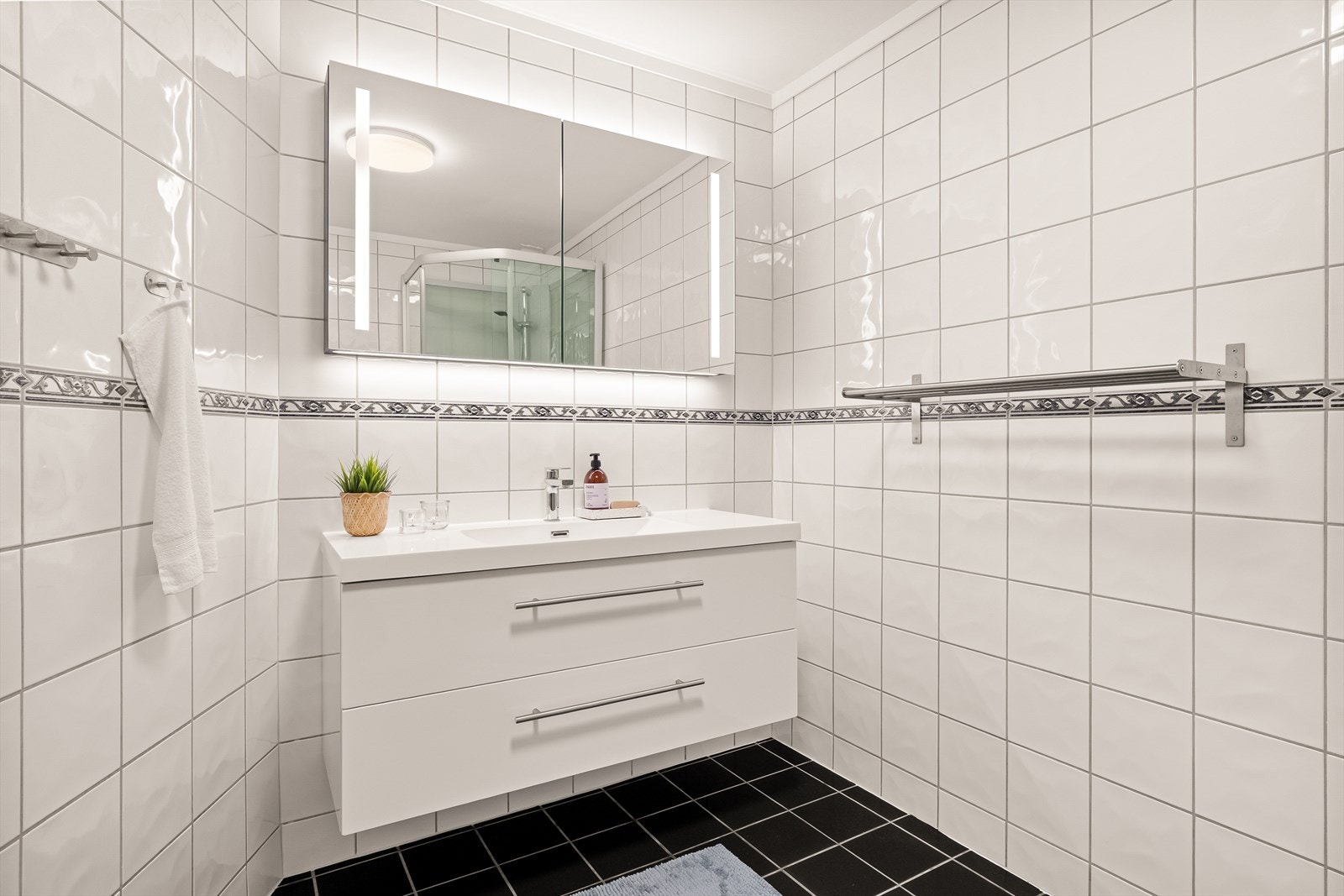 Flislagt bad i 2.etg som inneholder nyere baderommsinnredning med nedfelt servant, toalett og dusjkabinett. Galleribilde