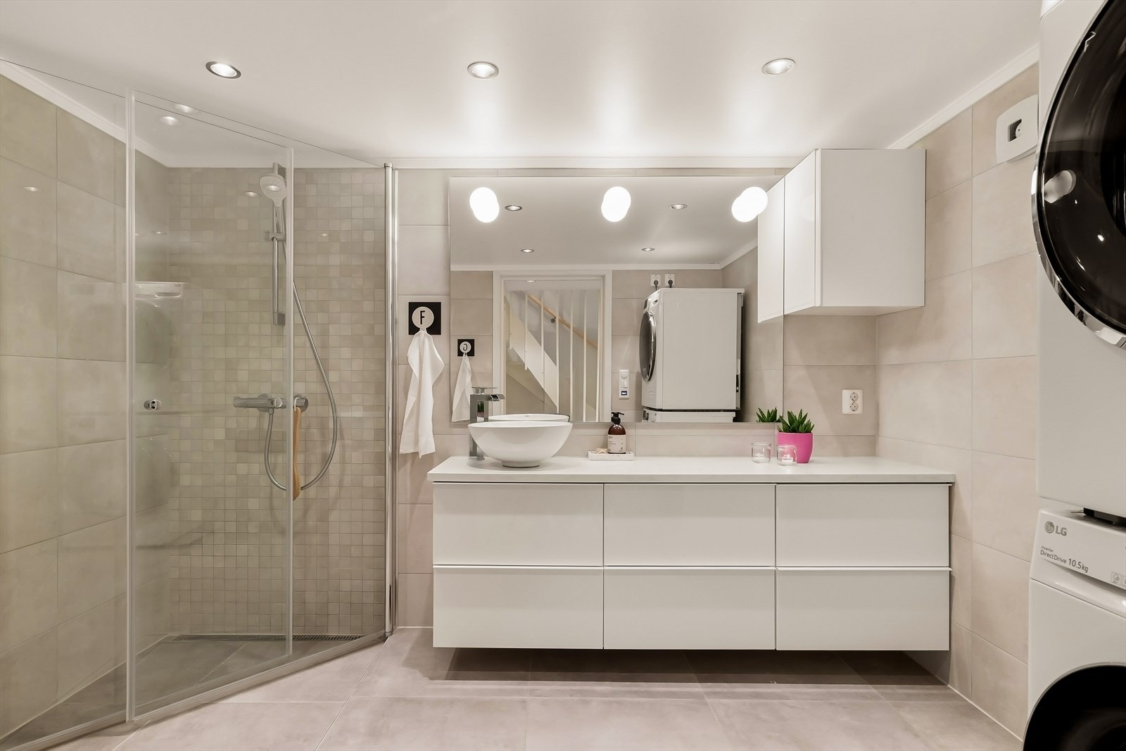 Badet har en stilren og funksjonell utforming med innredning som inkluderer nedfelt servant, veggmontert toalett og dusjhjørne med glassvegger. Galleribilde