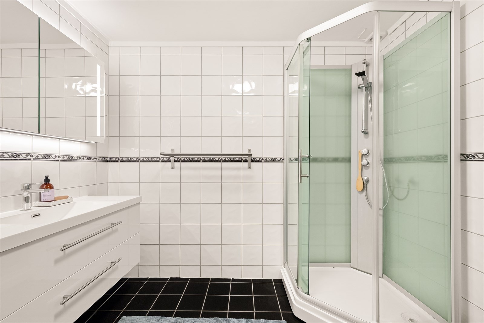 Flislagt bad i 2.etg som inneholder nyere baderommsinnredning med nedfelt servant, toalett og dusjkabinett. Galleribilde