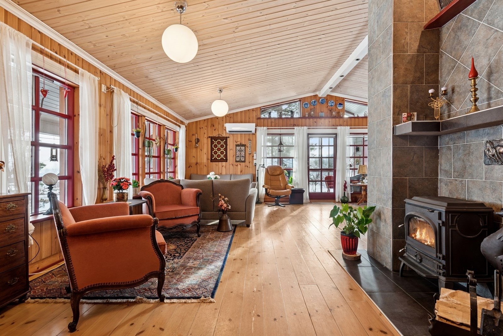 Den åpne stuen har store vindusflater som slipper inn rikelig med naturlig lys. Galleribilde