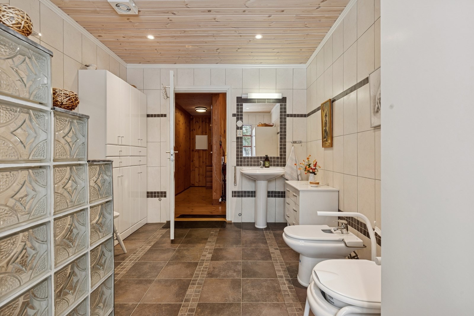 Delikat og flislagt bad i lyse, tidløse farger med behagelig gulvvarme som gir ekstra komfort året rundt. Galleribilde