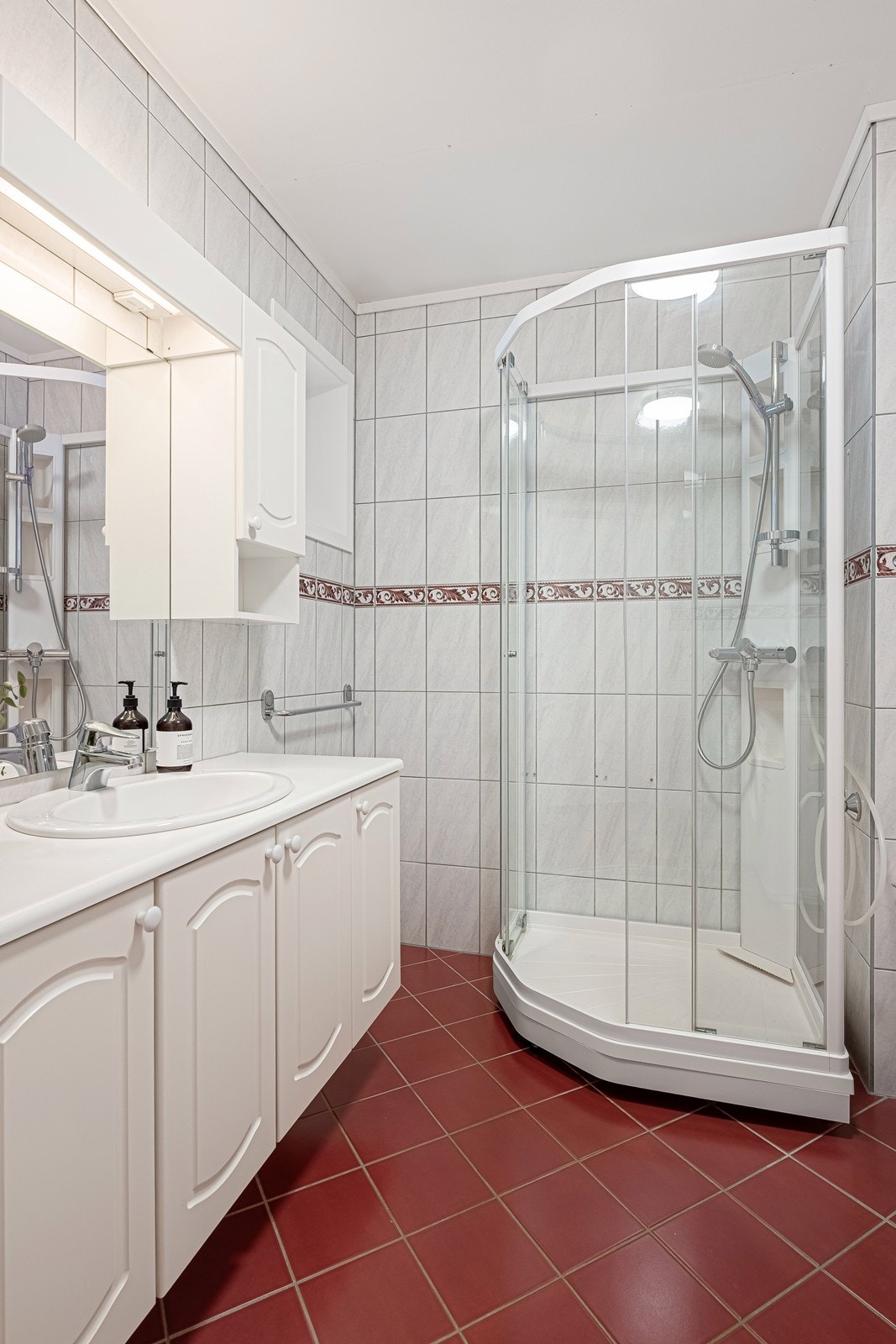 Badet er utstyrt med toalett, dusjkabinett og opplegg for vaskemaskin Galleribilde