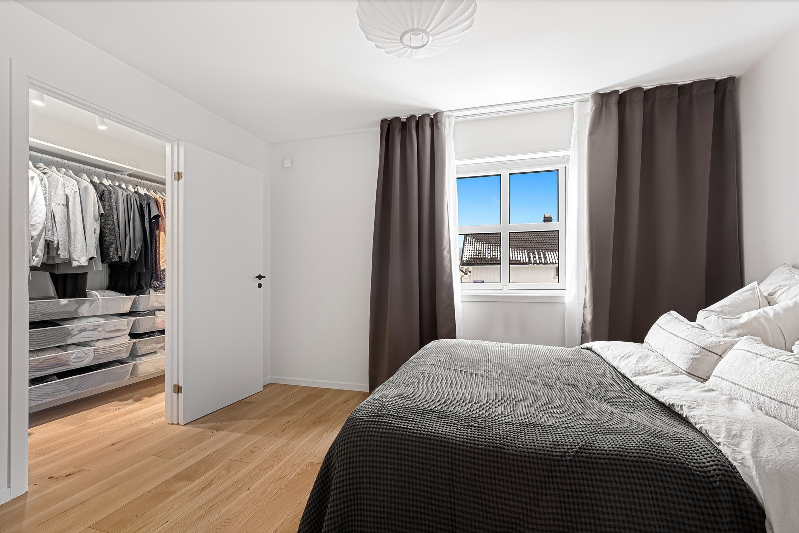 Romslig soverom malt i lyse farger med praktisk walk-in closet Galleribilde