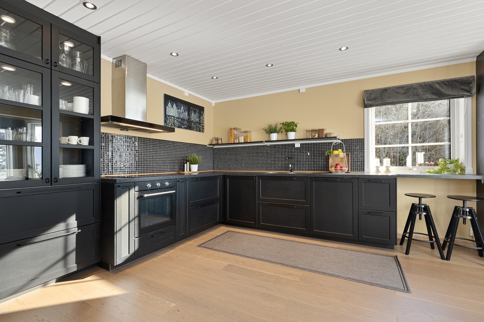 Kjøkkenet er fullt utstyrt med integrerte hvitevarer og har mosaikkfliser over benken. Galleribilde