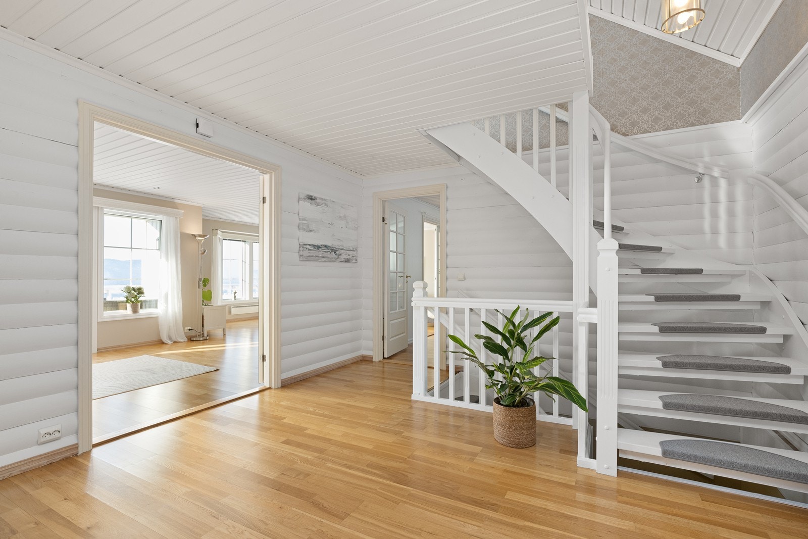 Den malte tretrappen leder opp til første etasje, som er boligens sosiale samlingspunkt. Galleribilde