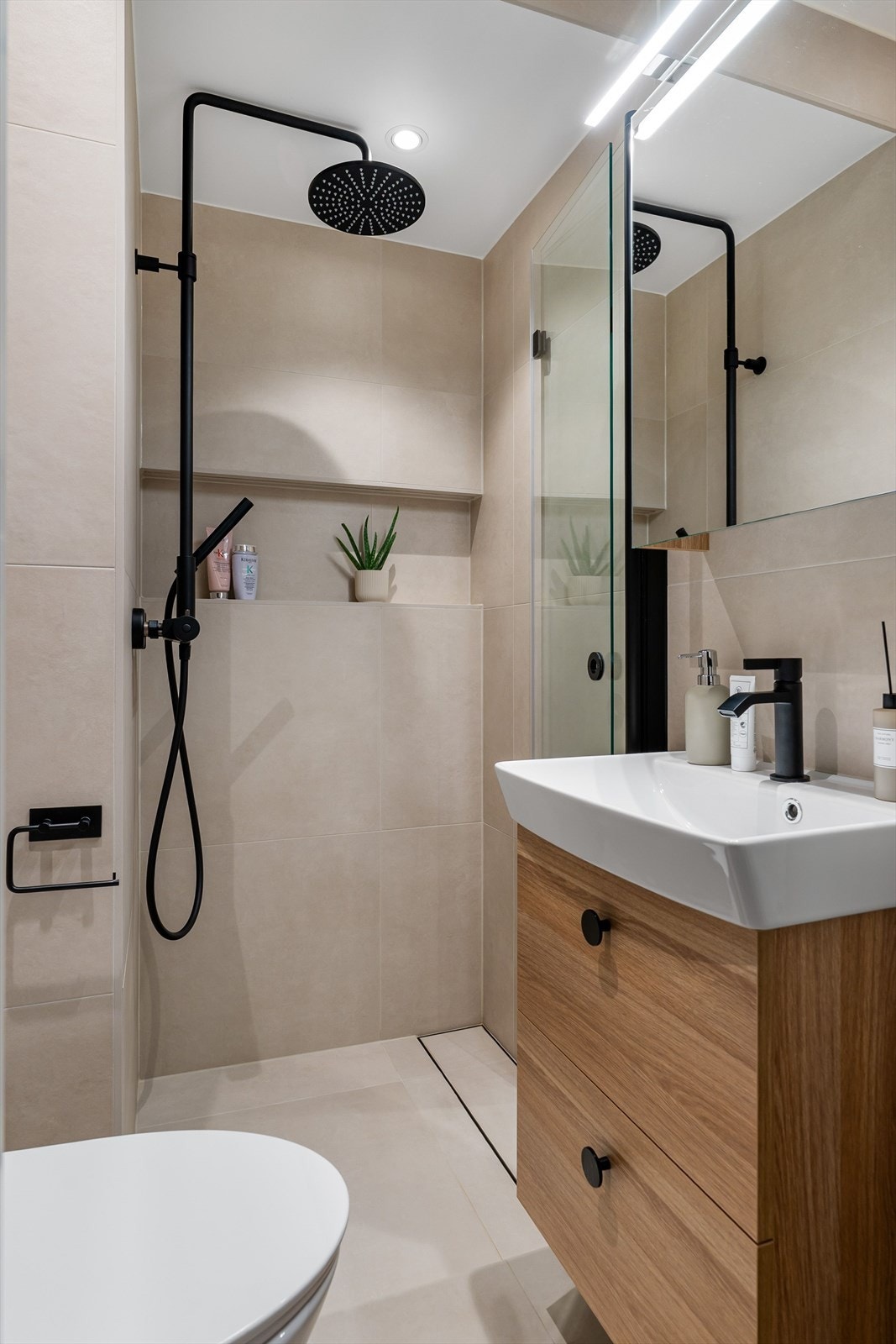 Badet har et moderne preg og flislagte vegger og gulv i stilrent fargevalg. Galleribilde