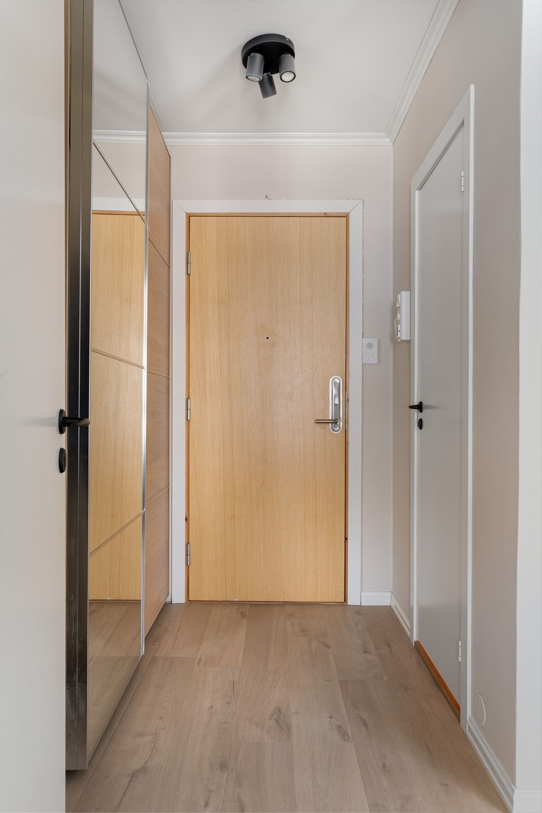 Velkommen inn! Via felles trappeoppgang kommer man til leilighetens i 3. etasje, og forbi inngangspartiet blir man møtt av en lys og innbydende entré. Galleribilde