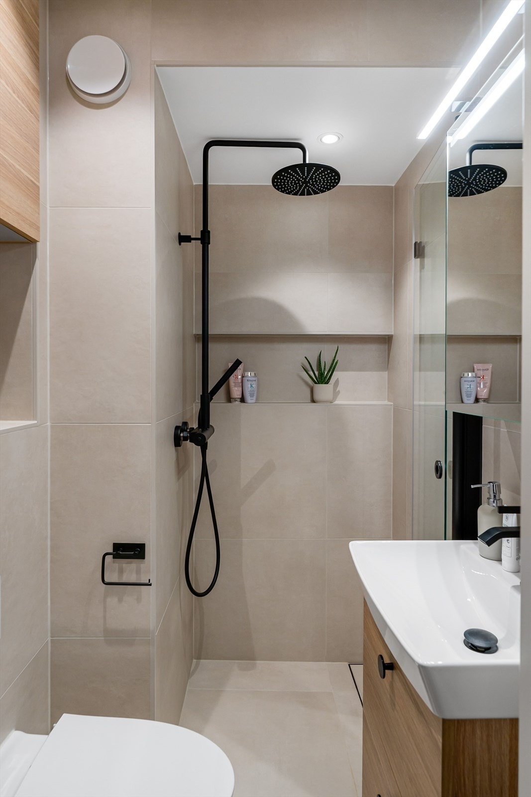 Badet er videre utstyrt med tropedusj, innfellbare glassdører, servant med speil, og vegghengt toalett. Galleribilde