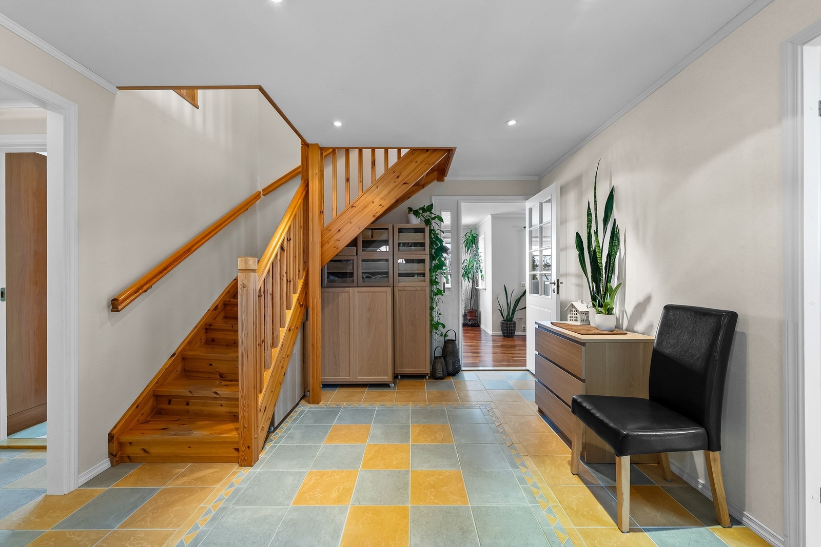 Hallen innenfor er romslig med god plass til møblement, og det er innredet en smart garderobeinnredning under trappen. Rommet har pen innerdør med glassfelt inn til stue. Galleribilde