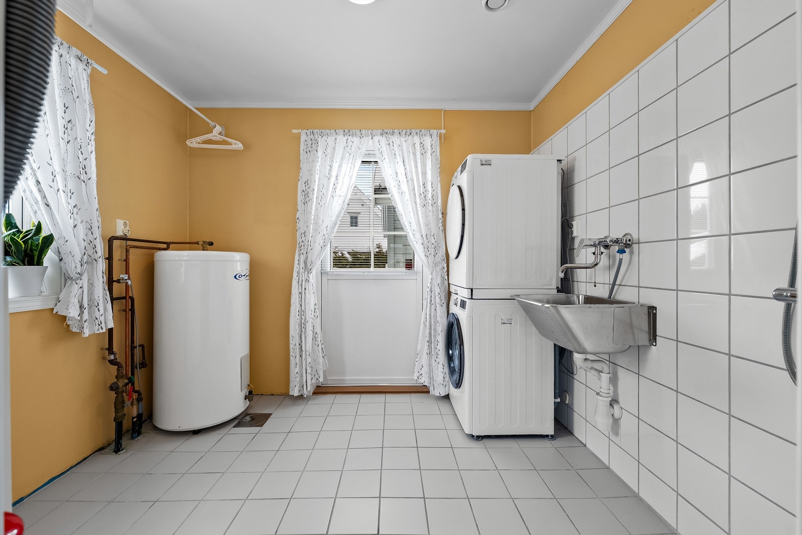 Det er adkomst til vaskerom fra hallen, og på vaskerommet er det egen inngangsdør med utgang til hagen på garasjesiden. Praktisk! Galleribilde