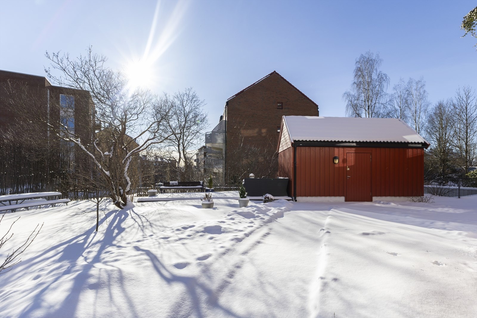 Hyggelig fellesområde med praktisk sykkelbod for beboerne. Området kan nytes på varmere dager med grønn plen og frodige omgivelser. Galleribilde