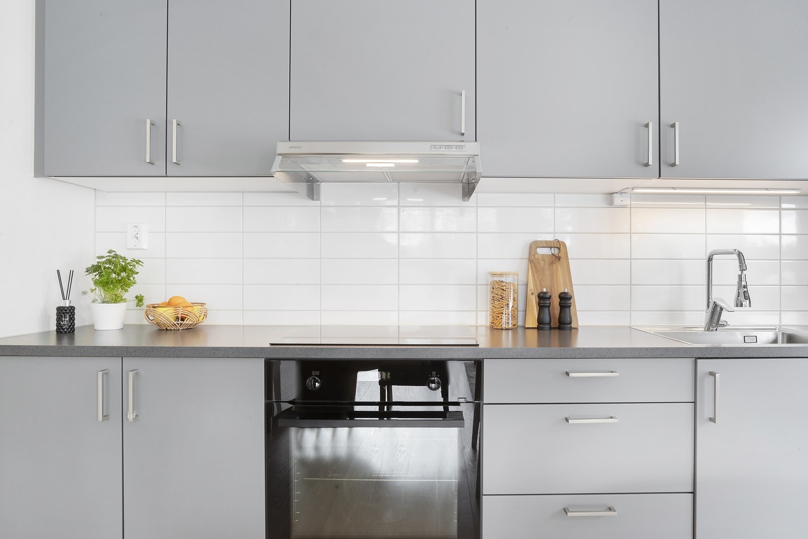 Kjøkkenet er utstyrt med integrerte hvitevarer, og kjøkkenventilatoren er diskret plassert i overskapet Galleribilde
