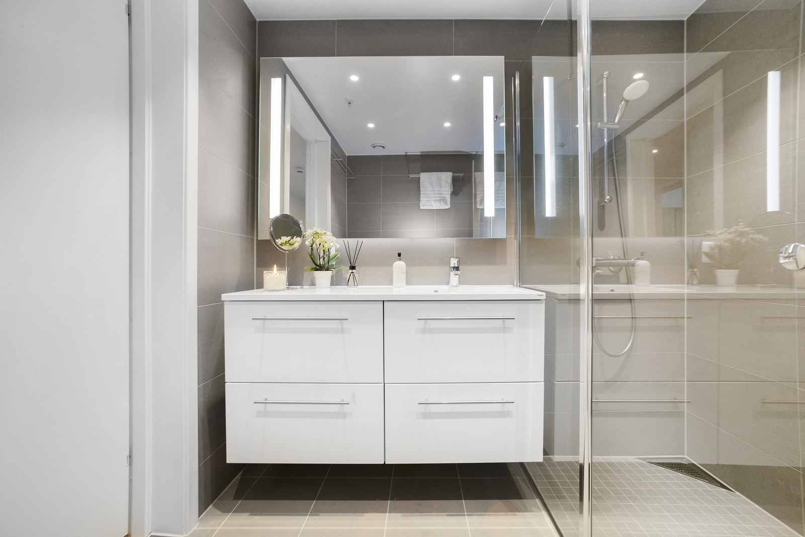 Veggene er kledd med fliser, himlingen er nedsenket med slett, malt overflate og integrerte downlights Galleribilde